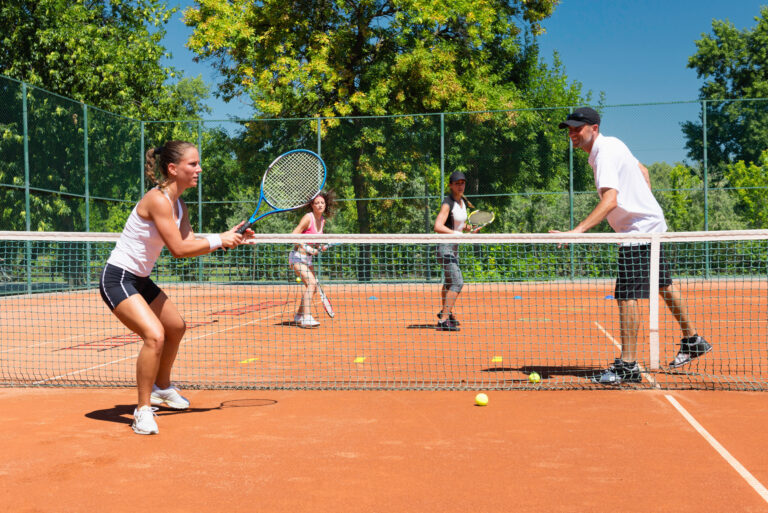 Gruppentraining Tennis mit mehreren Spielern auf dem Sandplatz
