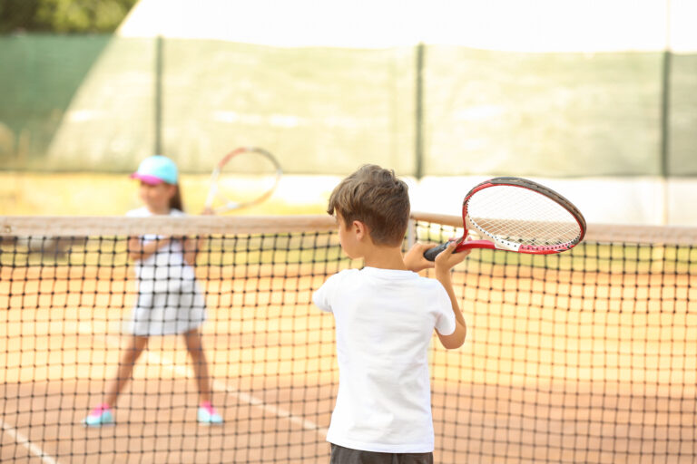 Kinder spielen Tennis im Training auf dem Platz